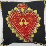Decorative pillow with embroidered heart design on a black background