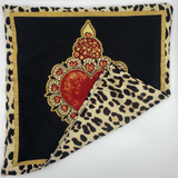 Decorative pillow with heart design and leopard print border on a white background